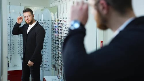 Man trying on new eyeglasses in the optical shop.