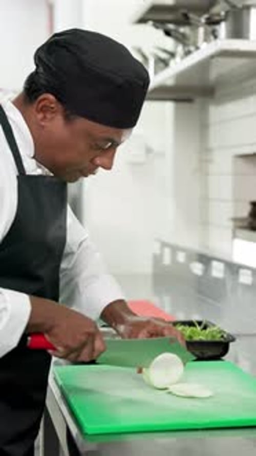 Man in Chef Uniform Slices Onions in Kitchen
