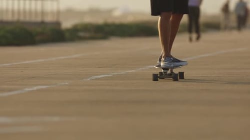 A Man in Sneakers Skateboarding on the Street