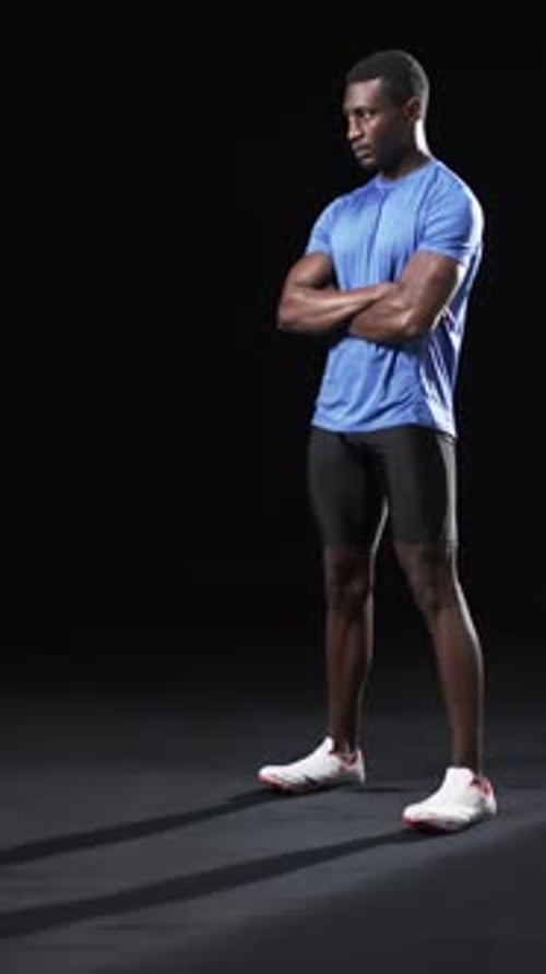 Confident Man Stands with Arms Crossed in Studio