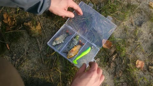 Fischer wählen Kunstköder aus der Tackle Box