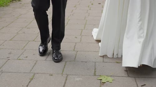 Elegant Wedding Couple Walking on Paved Path