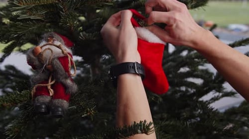 Decorating Christmas Tree with Red Stocking Ornament