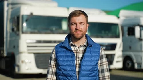Truck Driver Smiling in Front of Semi-Trucks