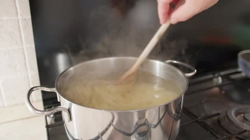 Chef Is Evaluating Cooking Spaghetti Pasta Italian In Pot With Boiling Water