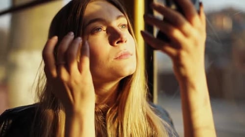 Woman Applies Makeup on Public Transport in Golden Light