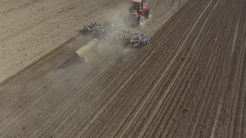 Big red combine working on the field cultivating and applying nitrogen ASP