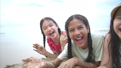 Happy children playing together in the sea, enjoying a fun summer day at the beach