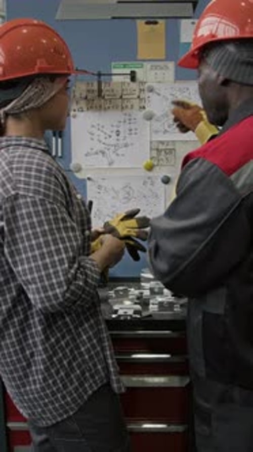 Vertical d'ingénieurs industriels discutant du dessin d'assemblage détaillé