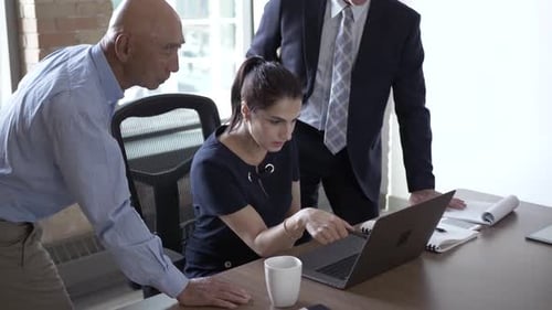 Team Meeting Around Laptop in Office Environment