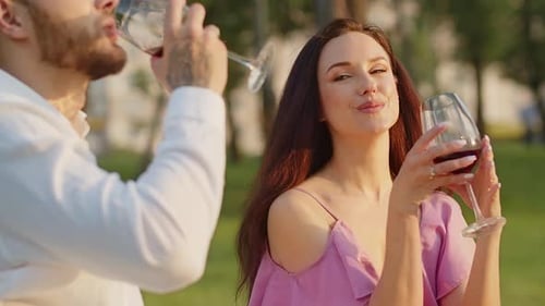 Loving Couple Toasting with Red Wine Outdoors