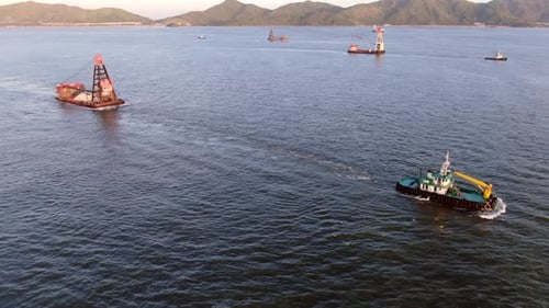 Tugboat pulling a small Barge in Hong Kong bay, Aerial view.
