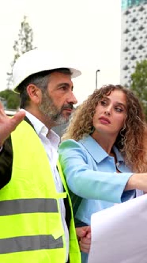 Construction Manager Briefing Architects on Site with Blueprints