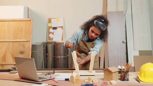 African American Carpenter Woman Hammering a Piece of Wood for a Chair in a Woodworking Shop Skilled