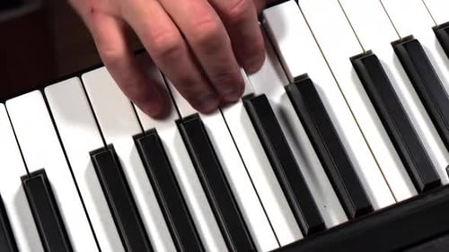 Hand Playing Piano Keys in Close Up
