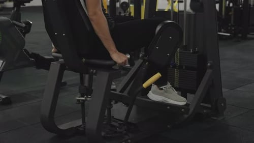 Woman in Black Pants in the Gym, Doing Leg Abductions on a Sports Machine.