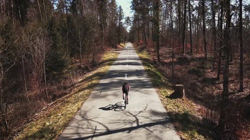 Man rides bicycle through forest in spring. Professional cyclist cycling on bike