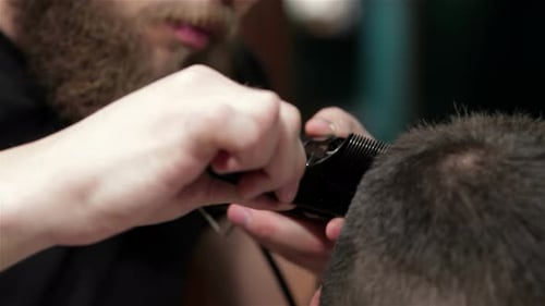 Barber Giving Man Haircut with Clippers and Comb