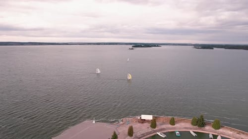 Vue aérienne de yachts amarrés à la jetée et de voiliers flottant sur un immense lac avec îlots