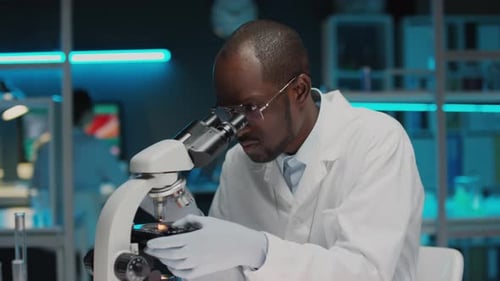 Scientist Carefully Using Microscope in a Lab