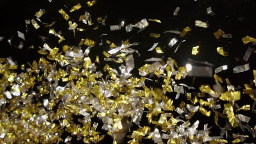Gold and Silver Confetti Falling on Black Background