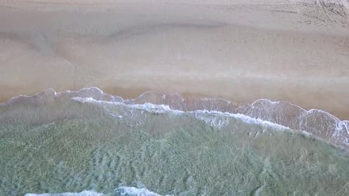 Tropical beach with colourful umbrellas and people enjoying the calm water