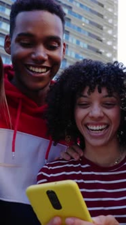 Happy Young Group of Diverse Teenage Friends Using Mobile Phone at City Street