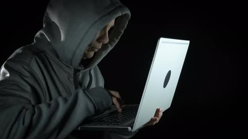 Young Adult Typing on Laptop in the Dark
