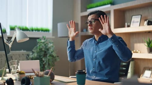 Smiling businessman gesturing during online meeting at informal office closeup