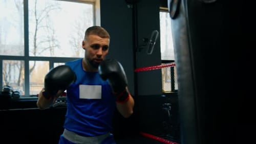 Boxing gym a boxer trains his punches hitting a punching bag