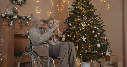 Infant and Senior Man with Christmas Tree