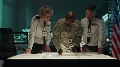 Adults Studying Map at Illuminated Table