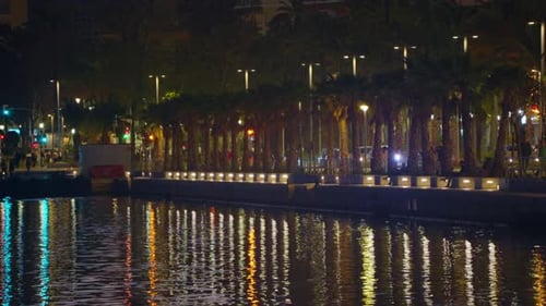 The Bright Lights of the Night City are Reflected in the Water Dark Time of Day During an Hour in a
