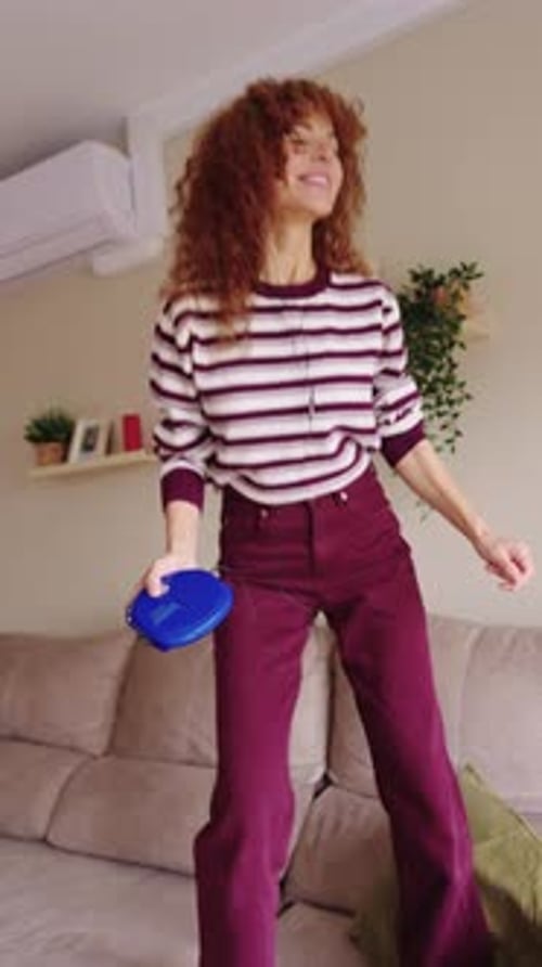 Woman Dancing Energetically on Sofa at Home