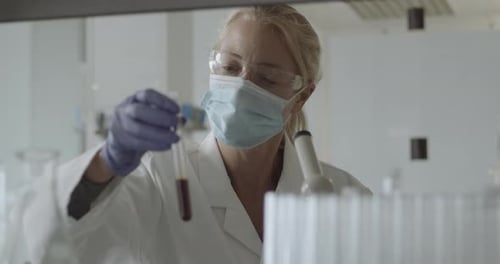 Female Scientist Examining a Test Tube in Lab