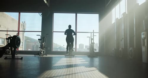 Stationary bike, workout and back with woman in gym for cardio, exercise machine and health