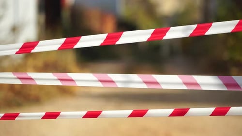 Fita de advertência vermelha e branca balançando no vento