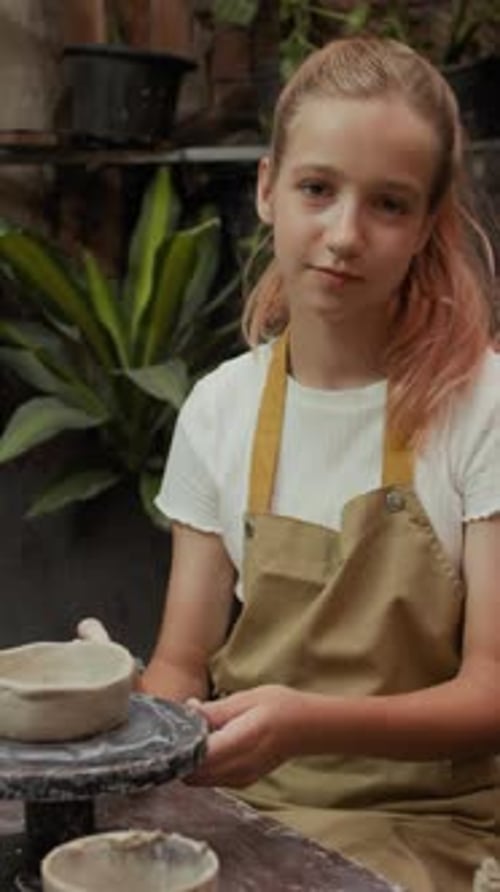 Portrait of Schoolgirl Crafting Clay Mug in Art Studio Vertical