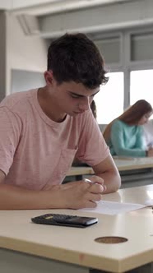 Joven estudiante haciendo un examen sentado en la universidad