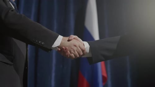 Business Handshake with Russian Flag Backdrop