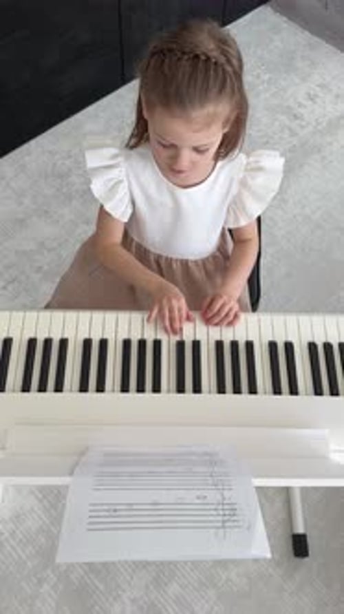 Cute Child Plays Piano in Home Setting