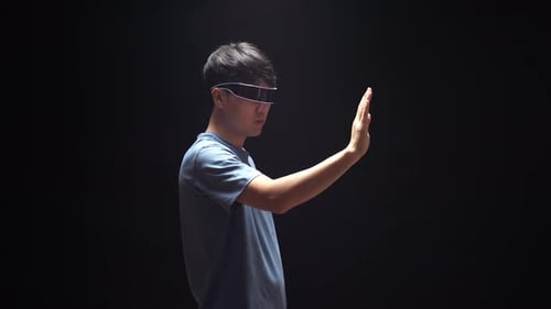 Side View Of Asian Man Double Touch And Swipe Virtual Reality While Using Futuristic Goggles