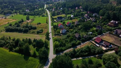 Road with Moving Cars in Countryside Area Near Mountain Village Aerial View