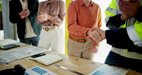 Apertando as mãos, aplausos e empreiteiro com a equipe de construção no local para aprovação do planejamento da cidade