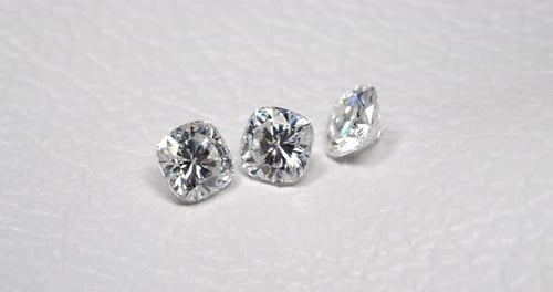 Funkelnde Diamanten auf weißem Lederhintergrund