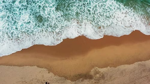 Sea Water Washes Sandy Beach with Group of People Walking
