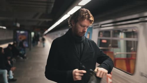 Rothaariger Mann wartet auf eine U-Bahn