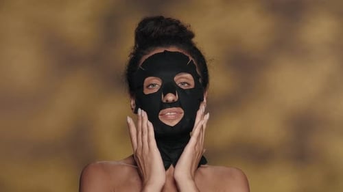 Woman Applies Black Facial Mask for Skincare