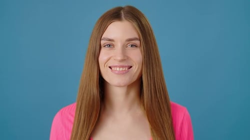 Young Woman Smiling at the Camera on Blue