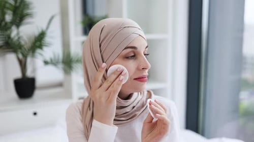 Woman in Hijab Cleansing Face in Bright Room